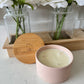 Top view of Blush Pink luxury candle in ceramic jar on bathroom.  Scented candle with lid on counter. 