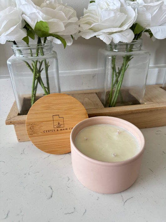 Top view of Blush Pink luxury candle in ceramic jar on bathroom.  Scented candle with lid on counter. 