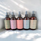 Five Room Spray scents in bottles.  Scents include Revitalize, Lavendar Fields, Island Breeze, Healing Tides, Vanilla Bean.